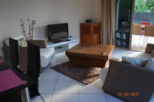 a living room with a coffee table and a tv at "Hanikea" Quiet & Pool Home in Papeete