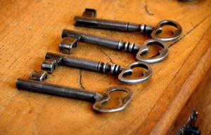 a group of metal keys on a wooden table at Pousada Solar da Ópera in Ouro Preto