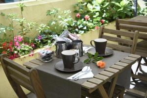 a wooden table with two cups and plates on it at Cerasella B&B in Naples