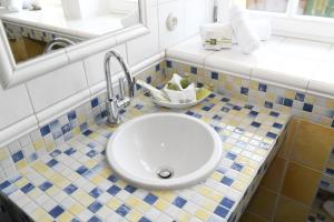 ein Badezimmer mit einem weißen Waschbecken und einem Spiegel in der Unterkunft Fachwerkhäuser Gager Haus „Strate“ in Gager