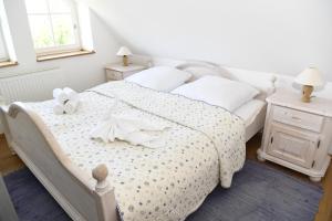 1 dormitorio con 1 cama blanca y 2 mesitas de noche en Fachwerkhäuser Gager Haus „Strate“, en Gager