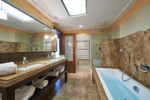 
a bathroom with a tub, sink, toilet and shower at Insotel Fenicia Prestige Suites & Spa in Santa Eularia des Riu
