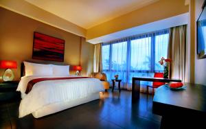 a bedroom with a large bed and a large window at 100 Sunset Kuta Hotel & Ballroom in Kuta