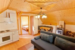 ein Wohnzimmer mit einem Sofa und einer Küche in der Unterkunft Bodnerhof in Arriach