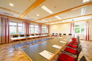 una sala de conferencias con mesas, sillas y ventanas en Natur- und Sporthotel Zuflucht, en Freudenstadt