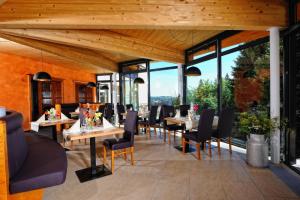 een restaurant met tafels en stoelen en grote ramen bij Natur- und Sporthotel Zuflucht in Freudenstadt