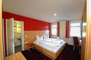 a hotel room with a bed and a bathroom at Natur- und Sporthotel Zuflucht in Freudenstadt +14 photos