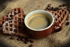 a cup of coffee next to waffles and coffee beans at Hotel Imperial - Liburnia in Opatija