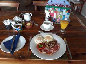 a wooden table with a plate of food on it at Moonglow Guesthouse in Simonʼs Town