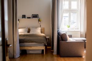 a bedroom with a bed and a window and a chair at Apartmán v centru in Šumperk