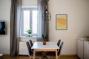 a dining room with a table and chairs and a window at Apartmán v centru in Šumperk +39 photos