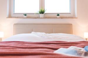 ツィングストにあるStrandhaus Lindenstraßeのベッド1台(赤毛布付)