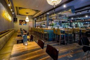a restaurant with wooden tables and chairs and a bar at Slapen bij hofman in Alkmaar