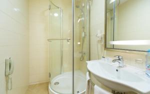 a bathroom with a shower, sink, and toilet at Hotel Garden Ring in Moscow