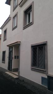 un edificio blanco con una puerta y dos ventanas en La Casa dei Gelsi en Castel Gandolfo