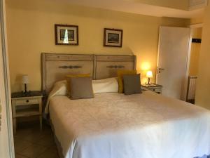 ein Schlafzimmer mit einem großen weißen Bett mit zwei Tischen in der Unterkunft La casa di Marilena in Taormina