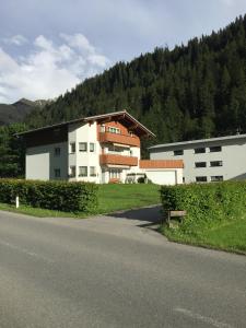 a building on the side of a road next to a house at Landhaus Lackner in Klösterle