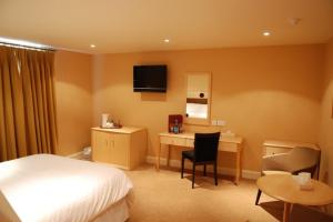a hotel room with a bed and a desk at The Trouville Bournemouth in Bournemouth