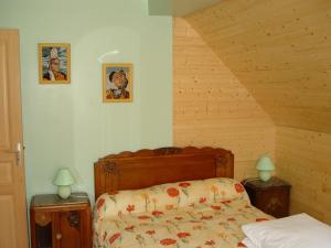 a bedroom with a bed and two pictures on the wall at le moign-locations in Camaret-sur-Mer