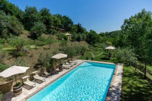 een uitzicht over een zwembad met stoelen en parasols bij Agriturismo Nibbiano in Montepulciano