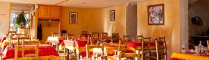 a restaurant with tables and chairs with red and yellow at Hôtel Restaurant Les Alpins in Saint-Julien-en-Beauchêne
