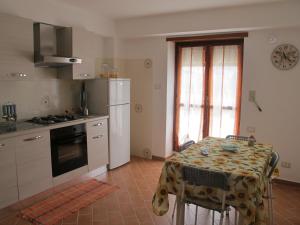 uma cozinha com uma mesa e um frigorífico branco em Casa dei Girasoli - Formia centro em Formia