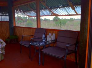 Habitación con 2 sillas, mesa y ventana en Everglades Chickee Cottage & Bungalow - Ochopee, en Ochopee
