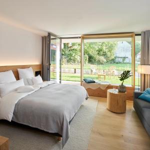 um quarto com uma cama grande e um sofá em meinwolfsburg hotel auf dem rittergut vormals Yard Boarding Hotel em Wolfsburg