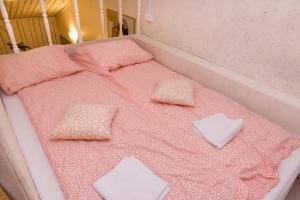 ヴィボルグにあるАпарт-коттедж Fashion-mini с сауной и зоной барбекю в Выборгеのピンクのシーツと枕が付いたベッド