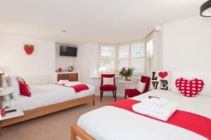 1 dormitorio con 2 camas, mesa y sillas en Strawberry Fields, en Brighton & Hove