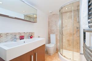 a bathroom with a sink and a shower and a toilet at Strawberry Fields in Brighton & Hove