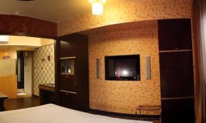 1 dormitorio con 1 cama y TV en la pared en Beckham Motel, en Luzhu