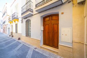 una porta di legno sul lato di un edificio di Theodora Chica 1 a Málaga