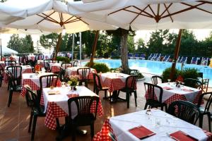 a restaurant with tables and umbrellas and a pool at Camping Village Panoramico Fiesole in Fiesole +128 photos