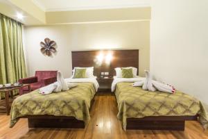 a hotel room with two beds with towels on them at Diamond Hotel in Varanasi