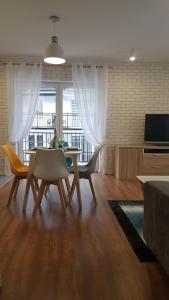 a living room with a table and chairs and a television at Apartament Juzo in Szklarska Poręba