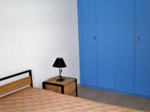 パラヴァ・レ・フロにあるLa coquilleのベッドルーム(青いドア、テーブルの上にランプ付)