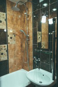 La salle de bains est pourvue d'une douche, d'un lavabo et d'une baignoire. dans l'établissement Prime Home, à Tchernihiv