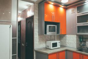 a kitchen with orange cabinets and a microwave at Prime Home in Chernihiv