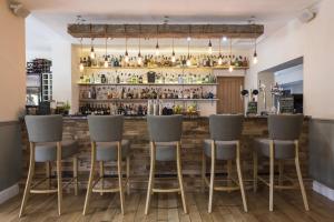 a bar with gray stools in a restaurant at The Lovat, Loch Ness in Fort Augustus