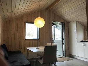 a dining room with a table and a lamp at Sdr. Felding camping & hytteby in Sønder Felding