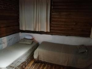 a bedroom with two beds and a window at Cabañas Buen Ayre in Villa Rumipal