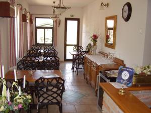 a restaurant with tables and chairs in a room at Penzion Večerka in Lednice