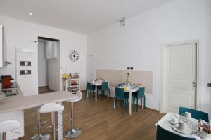 a kitchen and dining room with tables and chairs at Musto Suites & Rooms in Naples