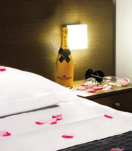 een fles champagne naast een bed met roze bloemen bij Hotel Cristian in Giugliano in Campania