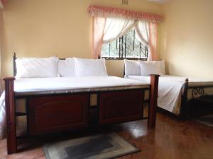 two beds in a room with a window at Bright Star Hotel in Arusha