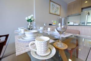 a glass table with a cup and a wine glass at Rain Chaam Beach Condo Wifi 4Guests 2Beds in Cha Am