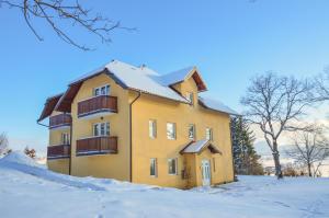 un edificio giallo con neve per terra di Grand Hills Zlatibor a Zlatibor