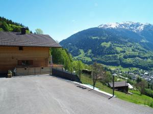 a large parking lot in front of a house with a mountain at Haus grüner Wald in Bartholomäberg