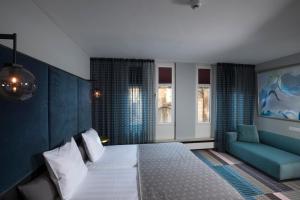 a hotel room with a bed and a couch at Hotel Derlon in Maastricht